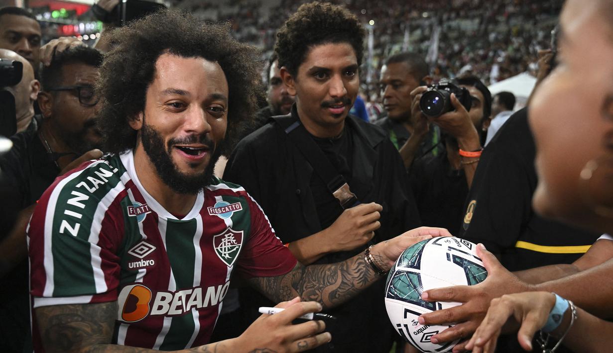<p>Marcelo memberikan tanda tangan ke penggemar saat perkenalan pemain baru Fluminense di Stadion Maracana, Rio de Janeiro, Brasil, Sabtu (11/03/2023) WIB. Mantan pemain Real Madrid tersebut bergabung hingga Desember 2024. (AFP/Carl De Souza)</p>
