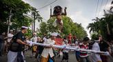 Umat Hindu membawa Ogoh-ogoh, patung yang melambangkan roh jahat, selama pawai menjelang Nyepi di Surabaya pada Rabu 18 Maret 2026. Menyambut datangnya Hari Raya Nyepi, umat Hindu di kota Surabaya, Jawa Timur, menggelar pawai Ogoh-ogoh. (JUNI KRISWANTO/AFP)