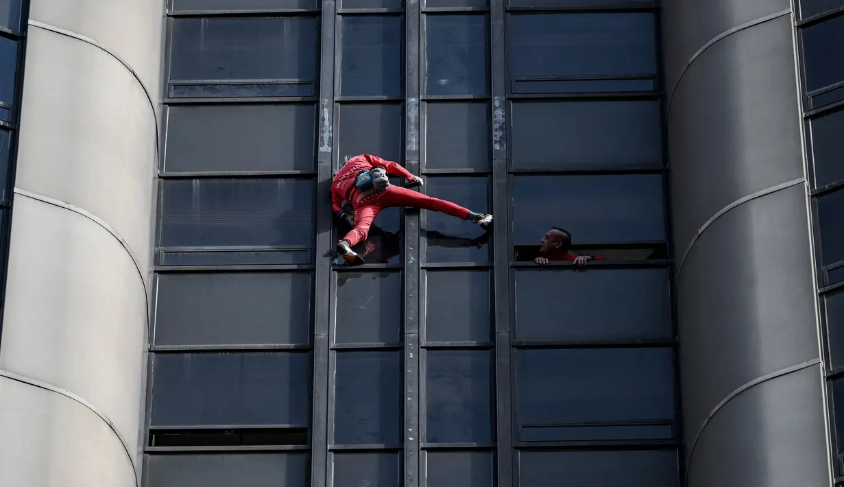 Alain Robert, pendaki bangunan pencakar langit asal Prancis memanjat Menara Montparnasse di Paris, Prancis, Rabu (12/10/2022). Alain Robert yang dikenal sebagai Spiderman Prancis itu kembali beraksi dengan memanjat Menara Montparnasse yang memiliki ketinggian 210 meter. (Bertrand GUAY/AFP)