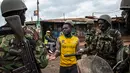 Polisi Kenya menginterogasi demonstran di daerah Kawangware di Nairobi, Kenya (10/8). Presiden Kenya Uhuru Kenyatta menang dalam pemilihan presiden, Jumat (11/8/2017) waktu setempat. (AFP Photo/Patrick Meinhardt)