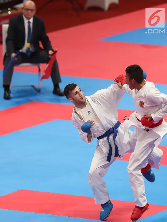 Karateka putra Indonesia, Rifki Ardiansyah Arrosyiid saat bertarung melawan Amir Mahdi Zadeh dari Iran di babak final nomor Kumite -60 kg di Arena Karate JCC Senayan, Jakarta, Minggu (26/8). Rifki berhasil meraih medali emas. (Liputan6.com/Fery Pradolo)