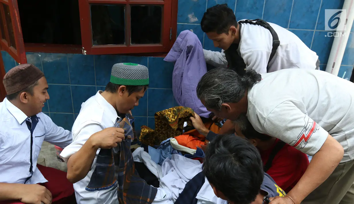 Korban kebakaran memilih bantuan berupa pakaian di posko pengungsian SDN 10/11 Pagi Cipinang Utara, Jakarta, Selasa (20/8/2019). Puluhan warga terdampak kebakaran di Kawasan Prumpung, Jatinegara saat ini masih sangat membutuhkan bantuan seperti alas tidur dan popok bayi. (Liputan6.com/Herman Zakhari
