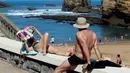 Seorang wanita membaca majalah saat berjemur di pantai Port Vieux, (Old Seaport) di Biarritz, barat daya Prancis, (19/4). Suhu di Prancis barat daya telah mencapai 27 derajat Celcius (80,6 Fahrenheit). (AP Photo / Bob Edme)