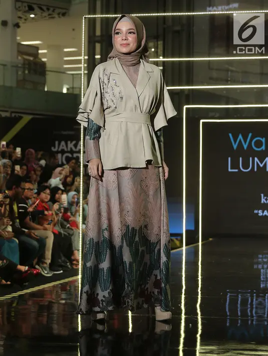 Aktris Dewi Sandra membawakan busana rancangan Wardah LUM (INA) x KAMI saat Jakarta Modest Fashion Week di Gandaria City, Jakarta, Minggu (29/7). KAMI mengangkat tema 'Sabaku'. (Liputan6.com/Herman Zakharia)