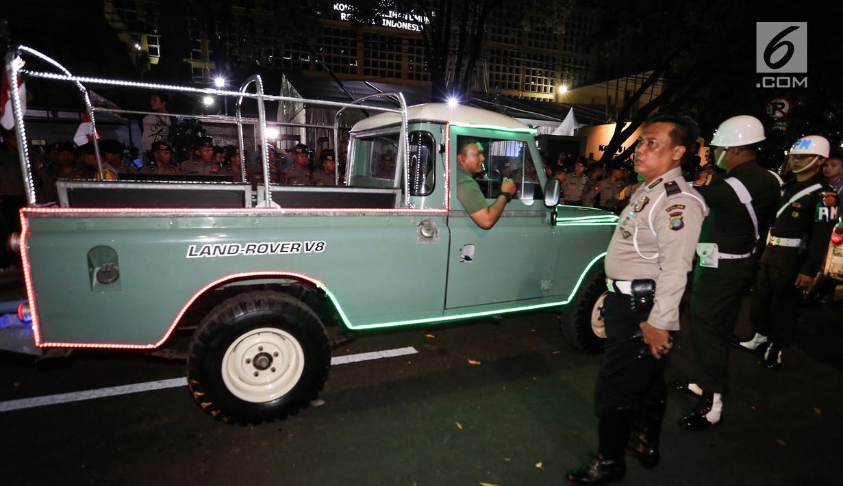 Petugas mengatur parkir mobil Land Rover klasik bak terbuka tumpangan Jokowi-Ma`ruf di gedung KPU Pusat, Jakarta, Jumat (21/9). Jokowi-Ma`ruf ke KPU untuk mengambil nomor urut Pilpres pasangan Capres dan Wapres 2019- 2024. (Liputan6.com/Fery Pradolo)