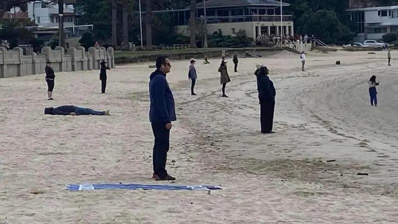 Viral Foto Menyeramkan Kelompok Berpakaian Serba Hitam Menghadap Pantai