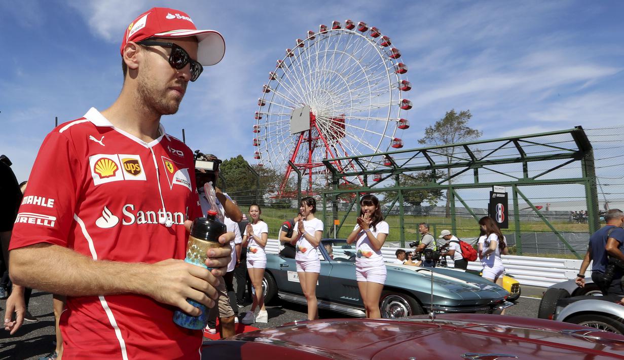 Pebalap Ferrari, Sebastian Vettel  saat santai pada sat balapan F1 GP Jepang di Sirkuit Suzuka, (8/10/2017). Vettel menempati peringkat kedua klasemen dengan 247 poin. (AP/Eugene Hoshiko)