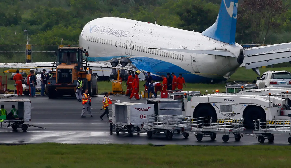 Pesawat maskapai China, XiamenAir tergelincir dari landasan saat melakukan pendaratan di bandara internasional Manila, Filipina, Kamis (16/8). Pesawat Boeing 737-800 itu berbelok dari landasan pacu karena hujan lebat terjadi. (AP/Bullit Marquez)