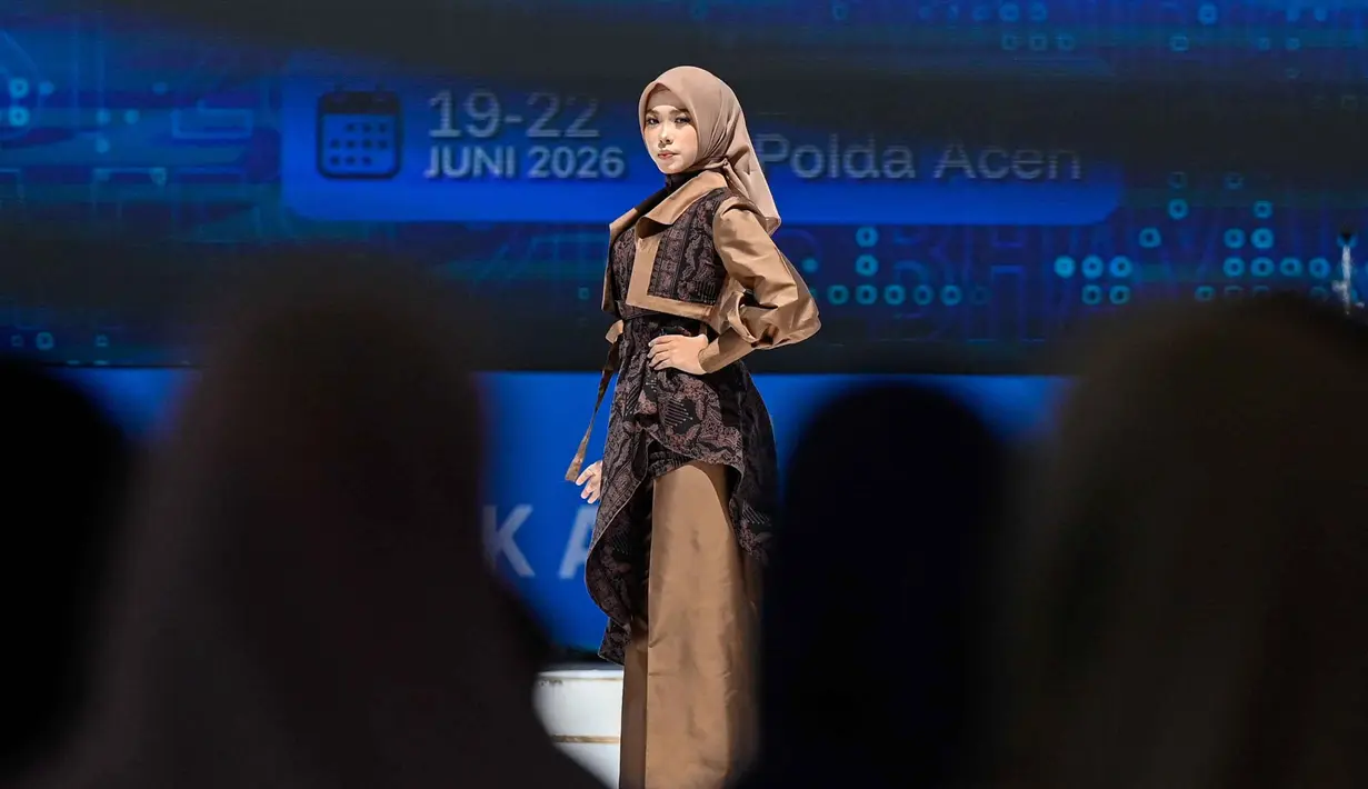 Seorang model menampilkan kreasinya saat peragaan busana Bhayangkara sebagai bagian dari peringatan 80 tahun Kepolisian Republik Indonesia, di Banda Aceh, Senin 22 Juni 2026. (CHAIDEER MAHYUDDIN/AFP)