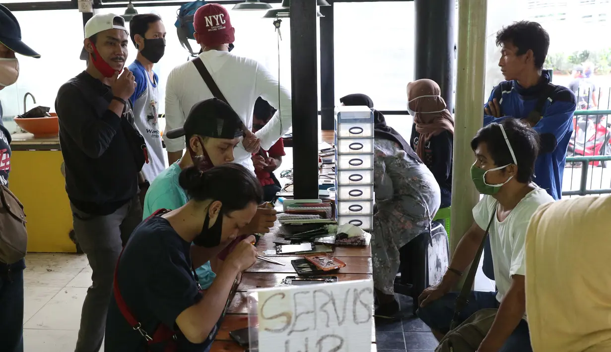 Aktivitas penjual jasa perbaikan telepon genggam di sekitar Mall Pusat Grosir Cililitan, Jakarta, Kamis (14/5/2020). Menurut salah satu penjual jasa, aktivitas mereka disebabkan penutupan Mall Pusat Grosir Cililitan sebagai imbas pemberlakuan PSBB.  (Liputan6.com/Helmi Fithriansyah)