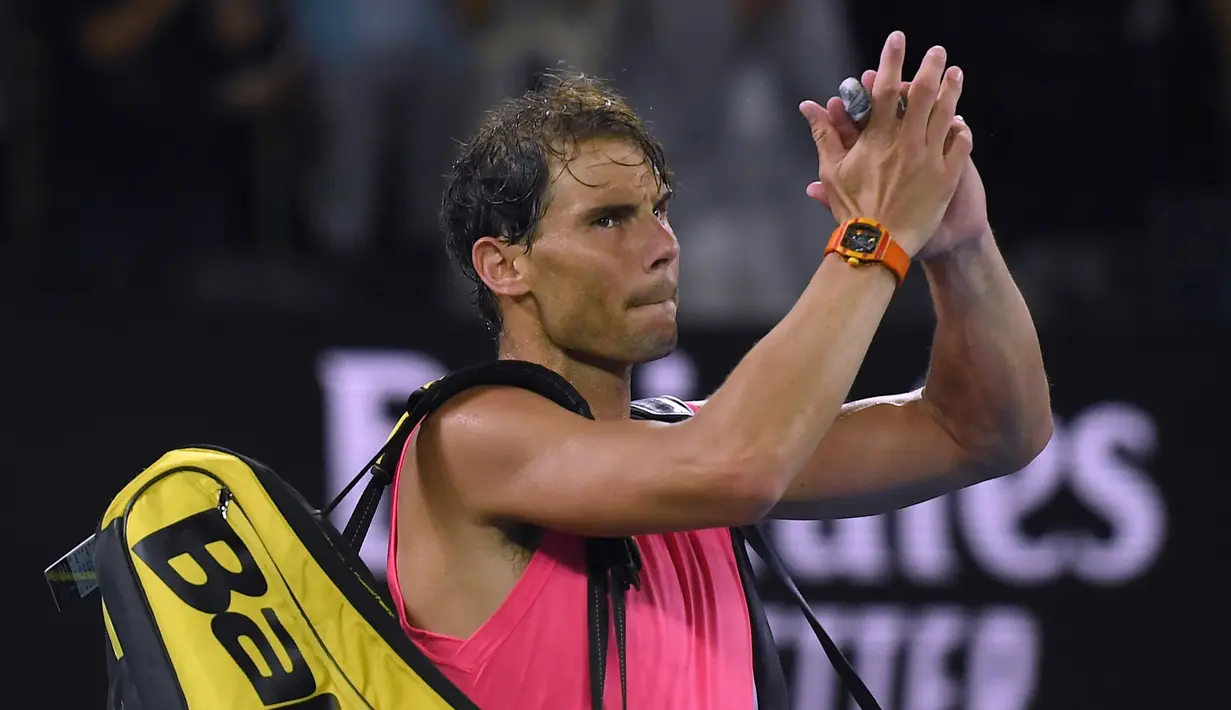 Petenis Spanyol, Rafael Nadal melambaikan tangan setelah dikalahkan Dominic Thiem dari Austria pada perempat final Australia Terbuka di Melbourne, Australia, Rabu (29/1/2020). Nadal harus menunda memburu Roger Federer sebagai pengoleksi Grand Slam putra terbanyak. (AP Photo/Andy Brownbill)
