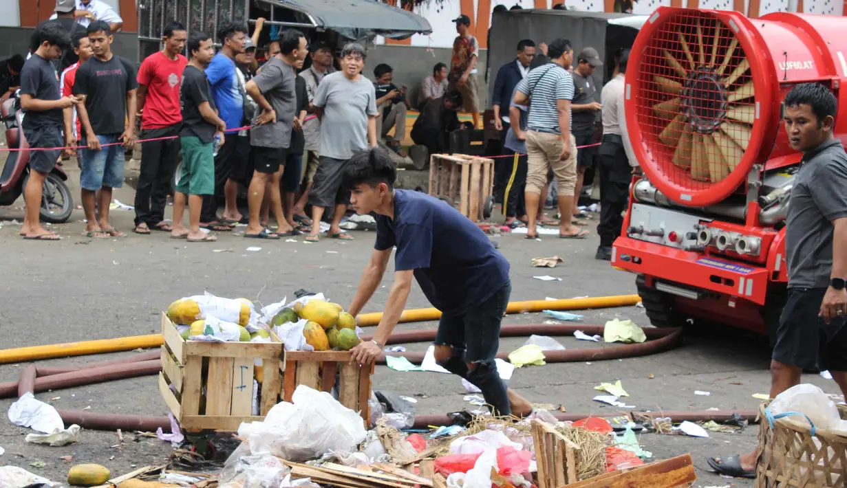 19 unit dan 95 personel pemadam kebakaran secara bertahap dikerahkan ke Pasar Induk Kramat Jati. Tampak dalam foto, pedagang berupaya menyelamatkan sisa dagangannya setelah api yang membakar Pasar Induk Kramat Jati Jakarta berhasil dipadamkan pada Senin (15/12/2025). (merdeka.com/magang/Rendi Saputra)
