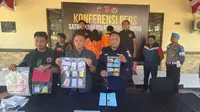 Kasat Reskrim Polresta Balikpapan Komisaris Polisi Ricky Sibarani (tengah) saat menunjukan barang bukti hasil kejahatan penipuan jual beli emas yang dilakukan pasangan suami istri. (Apriyanto/Liputan6.com)