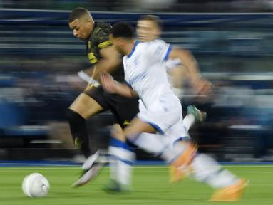 Pemain Paris Saint-Germain (PSG), Kylian Mbappe, menggiring bola saat melawan AJ Auxerre pada laga Liga Prancis, di Stade de I’Abbe Deschamps, Senin (22/5/2023). PSG menang dengan skor tipis 2-1. (AFP/Julien De Rosa)