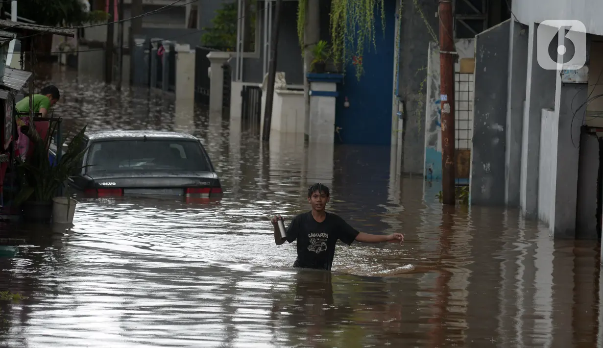 Warga berjalan menyusuri banjir yang merendam jalan dan rumah di RT 003/05, Pejaten, Jakarta, Sabtu ( 20/2/2021). Curah hujan yang tinggi sejak malam hingga dini hari mengakibatkan sejumlah kawasan terendam banjir. (merdeka.com/Imam Buhori)