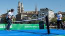 Petenis asal Swiss, Roger Federer (kiri) melakukan serve ke arah petenis asal Inggris, Andy Murray pada pertandingan amal The Match For Africa 3 di sebuah lapangan kecil yang berada di atas sungai Kota Zurich, Senin (10/4). (Ennio Leanza/Keystone via AP)