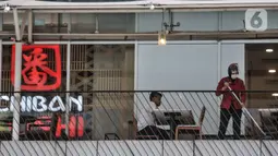 Pekerja membersihkan area restoran kawasan Soedirman, Jakarta, Minggu (11/10/2020). Gugus Tugas Percepatan Penanganan Covid-19 mencatat adanya pelambatan kenaikan kasus positif atau aktif di Ibu Kota selama sebulan pemberlakukan PSBB yang diperketat. (merdeka.com/Iqbal S. Nugroho)