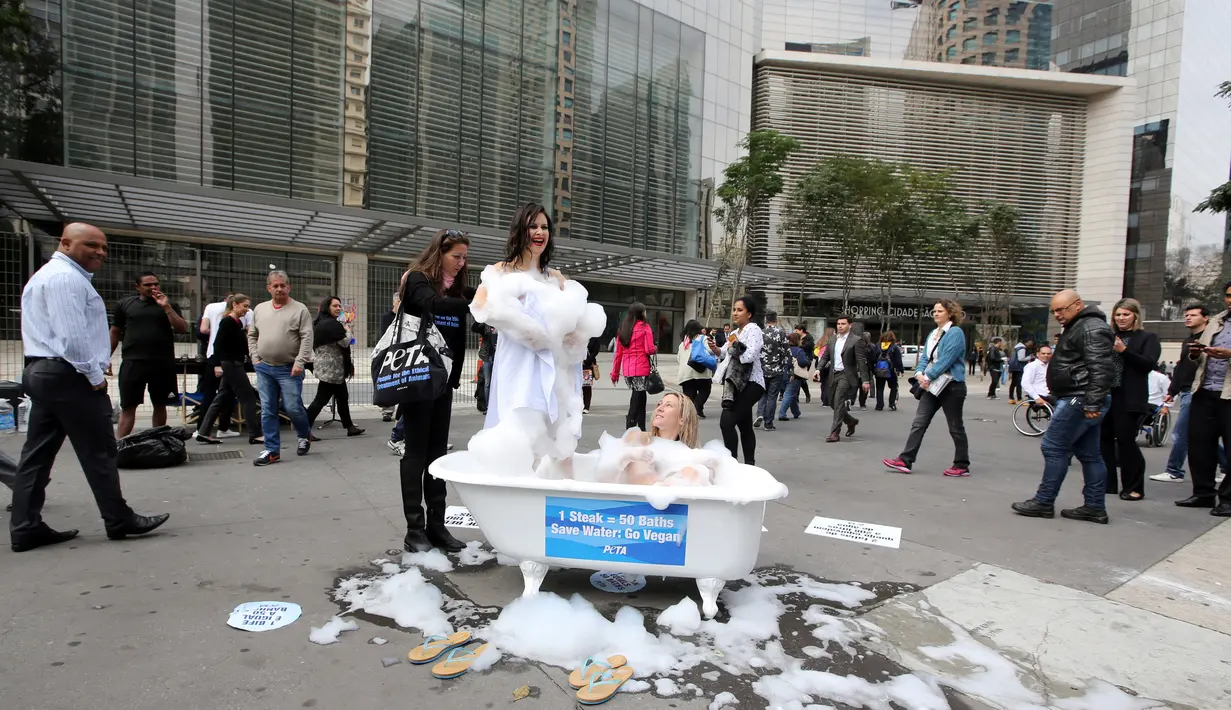 Aktivis wanita dari People for the Ethical Treatment of Animals (PETA) usai melakukan kampanye dengan mandi di Jalan Paulista di Sao Paulo, Brasil, Selasa (2/8). Aksi itu untuk mengajak masyarakat beralih ke pola makan vegetarian. (REUTERS/Paulo Whitaker)