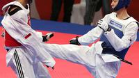 Atlet taekwondo Indonesia, Ibrahim Zarman bertarung melawan Gangmin Cho asal Korea Selatan di kelas putra under 63 Kg di lapangan taekwondo JCC, Jakarta, Rabu (22/8). Ibrahim gagal melaju ke semifinal. (Liputan6.com/Fery Pradolo)