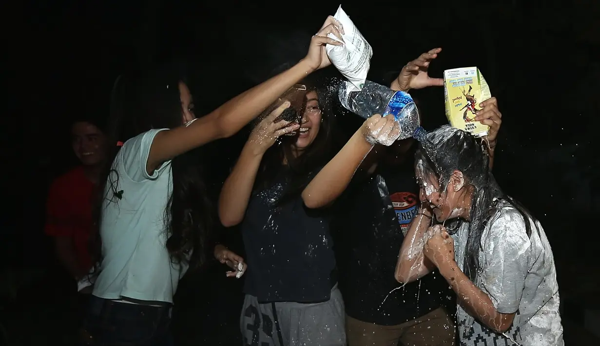 Tidak sampai di situ, dua teman lainnya juga ikut menaburkan tepung terigu di kepala Syifa beserta air mineral serta susu cair kemasan. Tak bisa mengelak, Syifa hanya terdiam pasrah dengan raut bahagia. (Bambang E.Ros/Bintang.com)