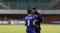 Alfred Riedl tengah berbincang dengan mantan anak asuhnya di Vietnam, Lee Chong Vinh pada sesi latihan di Stadion Maguwoharjo, Sleman, Sabtu (08/10/2016). (Bola.com/Nicklas Hanoatubun)