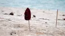 Topi dan kayu sebagai tanda gawang saat bermain bola dekat pantai di Desa Matwaer, Kei Kecil, Maluku (25/12/2017). Bermain bola di pasir menjadi daya tarik tersendiri bagi anak dan pmuda desa. (Bola.com/Nick Hanoatubun)