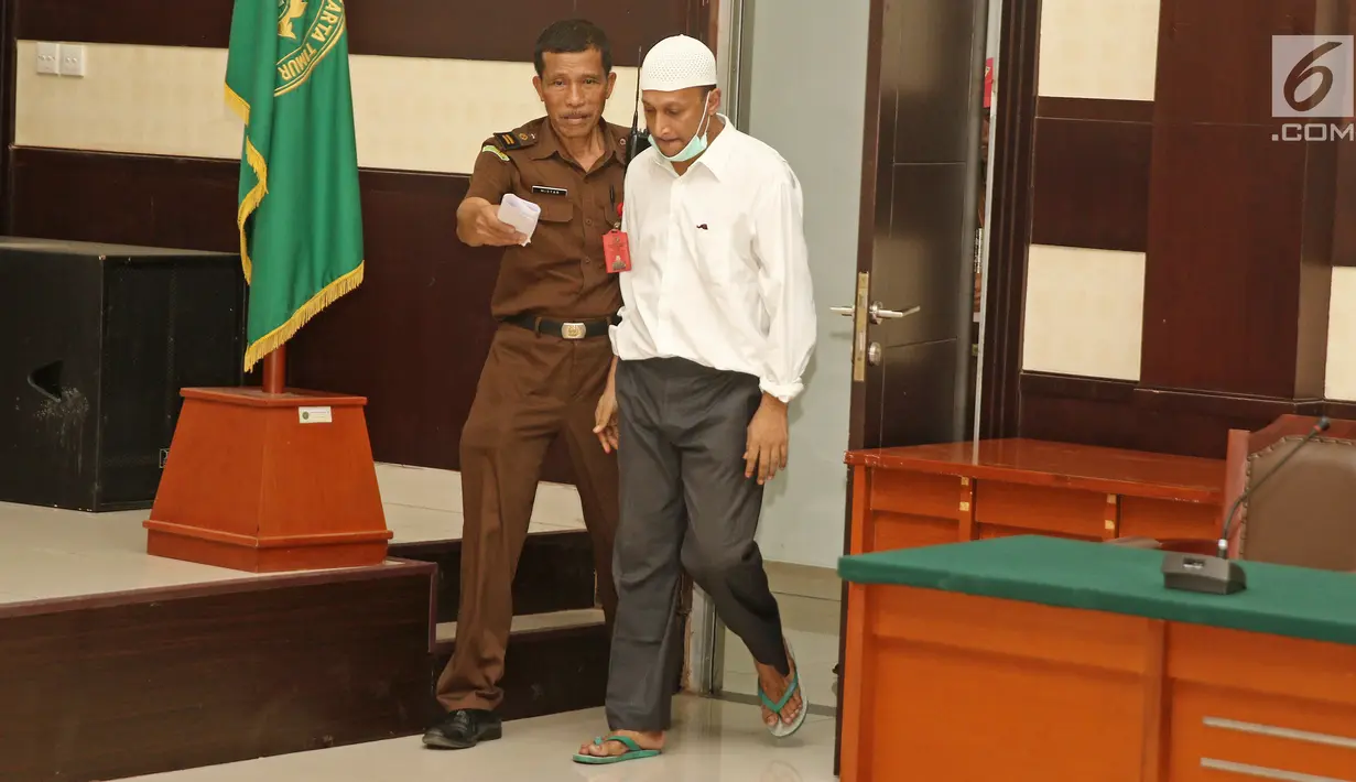 Terdakwa kasus penembakan dr Letty Sultri, dr Helmi memasuki ruang sidang PN Jakarta Timur, Kamis (29/3). Helmi didakwa menembak istrinya sebanyak enam kali di bagian badan. (Liputan6.com/Herman Zakharia)