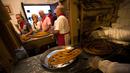 Karyawan meniriskan donat khas Spanyol atau churros usai digoreng di restoran dessert tradisional La Manueta, Pamplona, Spanyol, Rabu (10/7/2019). Churros memiliki tekstur renyah diluar dan lembut di dalam. (JAIME REINA/AFP)