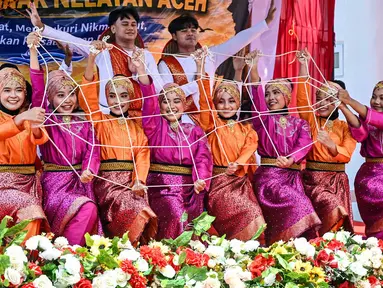 Seniman menampilkan tarian tradisional pesisir Rapai Geleng pada perayaan tradisi kenduri laut wilayah Panglima Laot Lok Kuala Cangkoi di Ulee Lheu, Banda Aceh, Aceh, Rabu (22/7/2026). (AFP/ Chaideer Mahyuddin).