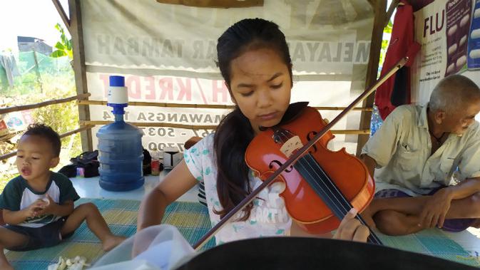 Jawa Nur Alam (13), gadis yang piawai memainkan alat musik biola yang videonya sempat ramai di media sosial. (Foto: Liputan6.com/Dian Kurniawan)