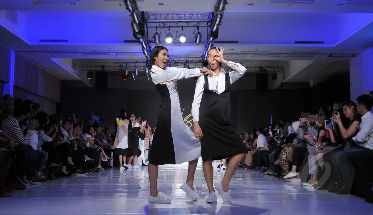 Dua model berpose memperagakan edisi Spring/Summer 2015 di show tunggal ISIS pada ajang Jakarta Fashion and Food Festival di Jakarta, Rabu (20/5). Rancangan Amot Syamsuri dan Andrea Risjad ini bertema "The City". (Liputan6.com/Herman Zakharia)