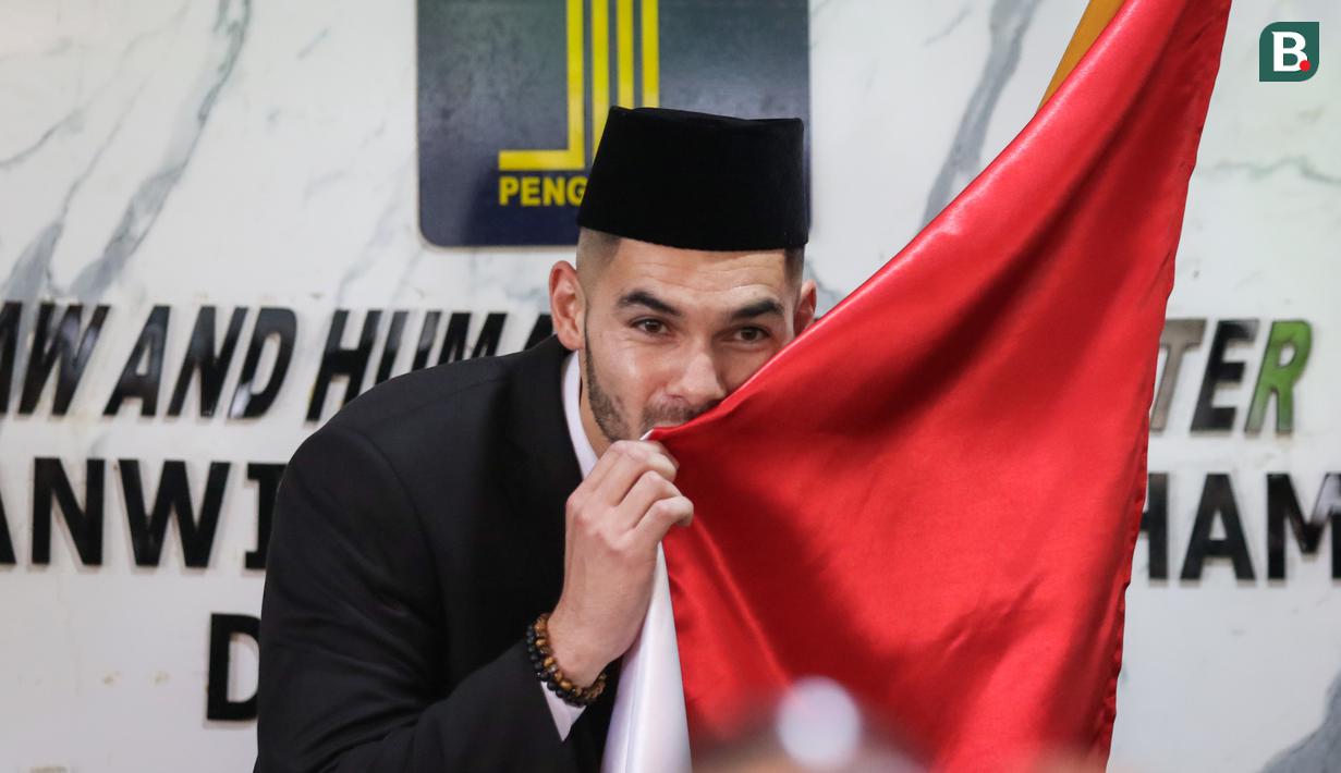 <p>Sandy Walsh mencium bendera Merah Putih di depan wartawan usai pengambilan sumpah janji setia pewarganegaraan Jordi Amat dan Sandy Walsh di Kantor Wilayah Kemenkumham DKI Jakarta, Cawang, Jakarta, Kamis (17/11/2022). (Bola.com/Bagaskara Lazuardi)</p>