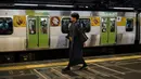 Seorang pria yang mengenakan kimono tradisional berjalan melewati kereta Yamanote Line yang penuh sesak di Stasiun Shinjuku di Tokyo, Jepang, Sabtu (25/5/2019). (AP Photo/Jae C. Hong)
