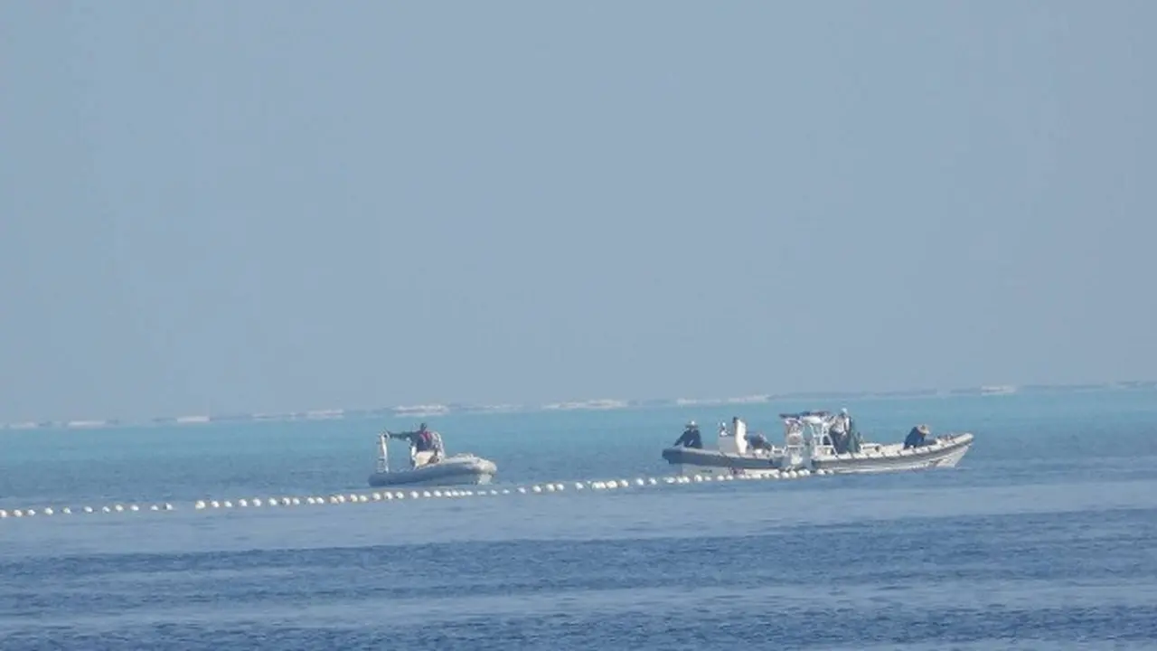 Gambar menunjukkan penghalang terapung dijaga oleh kapal China di wilayah yang dikenal di Filipina sebagai Bajo de Masinloc di Laut China Selatan. (Dok. Philippine Coast Guard)