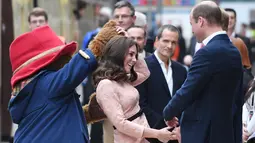 Pangeran William melihat Kate Middleton berdansa dengan seorang aktor berkostum Paddington di stasiun kereta Paddington, London, Senin (16/10). Kate dan William datang bersama Pangeran Harry, serta beberapa pemain film Paddington 2 (Chris J Ratcliffe/AFP)