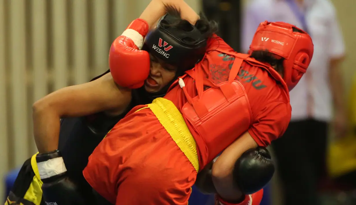 Atlet wushu Indonesia, Moria Manalu (kiri), membanting lawannya asal Turki, Nagihan Kalyoncu, di kelas Sanda Wanita 60 kg pada Kejuaraan Dunia Wushu 2015 di Istora Gelora Bung Karno, Senayan, Jakarta, Senin (16/11/2015). (Bola.com/Nicklas Hanoatubun)