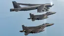 Pesawat Stratofortress B-52H Angkatan Udara Amerika Serikat (atas) terbang dalam formasi dengan pesawat tempur F-15K Angkatan Udara Korea Selatan di atas laut barat Semenanjung Korea saat latihan udara bersama di Korea Selatan, Senin (6/3/2023). Kementerian Luar Negeri Korea Utara pada 5 Maret 2023, meminta PBB untuk menuntut penghentian segera latihan militer gabungan oleh Amerika Serikat dan Korea Selatan di Semenanjung Korea. (South Korea Defense Ministry via AP)