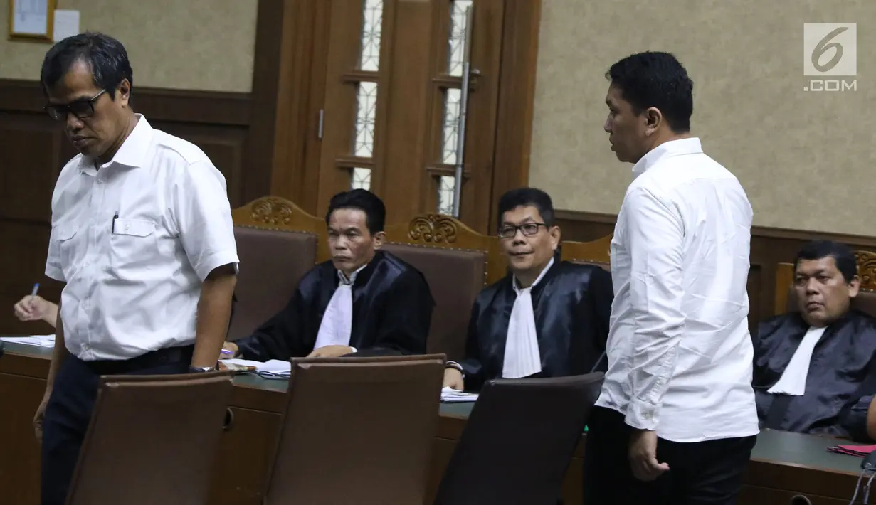Terdakwa suap DPRD Sumut, Tunggul Siagian dan Fahru Rozi bersiap menjalani sidang di Pengadilan Tipikor, Jakarta, Kamis (27/12). Tujuh mantan anggota DPRD Sumut didakwa menerima suap dari Gatot Pujo Nugroho. (Liputan6.com/Helmi Fithriansyah)