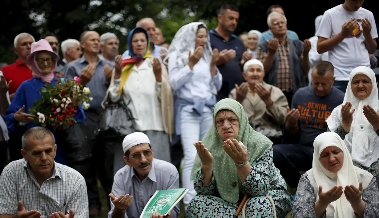  Warga berdoa di dekat truk yang membawa 136 peti mati korban pembantaian Srebrenica juli, 1995, di desa Visoko, Bosnia-Herzegovina, Kamis, (9/7/2015). Pasukan Serbia Bosnia dibantai, 8.000 etnis Muslim wafat pada waktu itu. (REUTERS/Stoyan Nenov)
