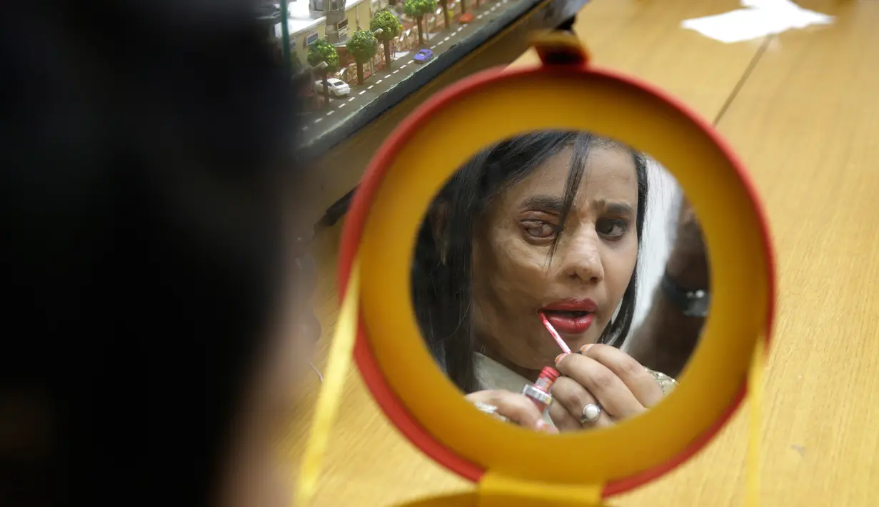 Korban siraman air keras memakai make up sebelum peragaan busana pada malam Hari Perempuan Internasional di Thane, Mumbai, India, Rabu (7/3). Acara ini bagian dari kampanye kesadaran bertajuk 'Stop Acid Sale'. (AP Photo/Rafiq Maqbool)