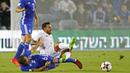 Gelandang Spanyol, Jonathan Viera, dijatuhkan gelandang Israel, Bibras Natcho, pada laga kualifikasi Piala Dunia 2018 di Stadion Teddy, Yerusalem,Senin (9/10/2017). Israel kalah 0-1 dari Spanyol. (AFP/Jack Guez)