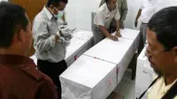 Sejumlah petugas mendata tiga peti jenazah TKI asal Sampang, yang tewas karena tertembak di Malaysia, di RS Bhayangkara, Polda Jatim, Surabaya. (Antara)