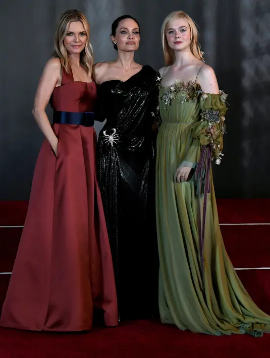 Aktris Elle Fanning (kanan) berpose dengan Michelle Pfeiffer dan Angelina Jolie di karpet merah saat menghadiri pemutaran perdana film Disney "Maleficent: Mistress of Evil" di Teater El Capitan di Hollywood (30/9/2019). (AFP Photo/Kevin Winter)