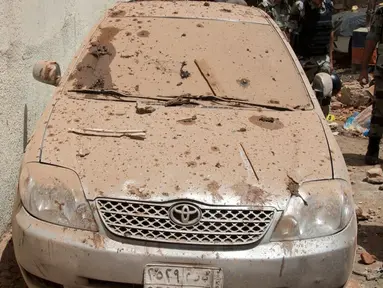 Sebuah mobil tertutup debu puing akibat ledakan bom bunuh diri di Mekkah, Arab Saudi (23/6). Sedikitnya 11 orang terluka akibat bom bunuh diri ini, lima di antaranya adalah anggota kepolisian. (Saudi Press Agency via AP)