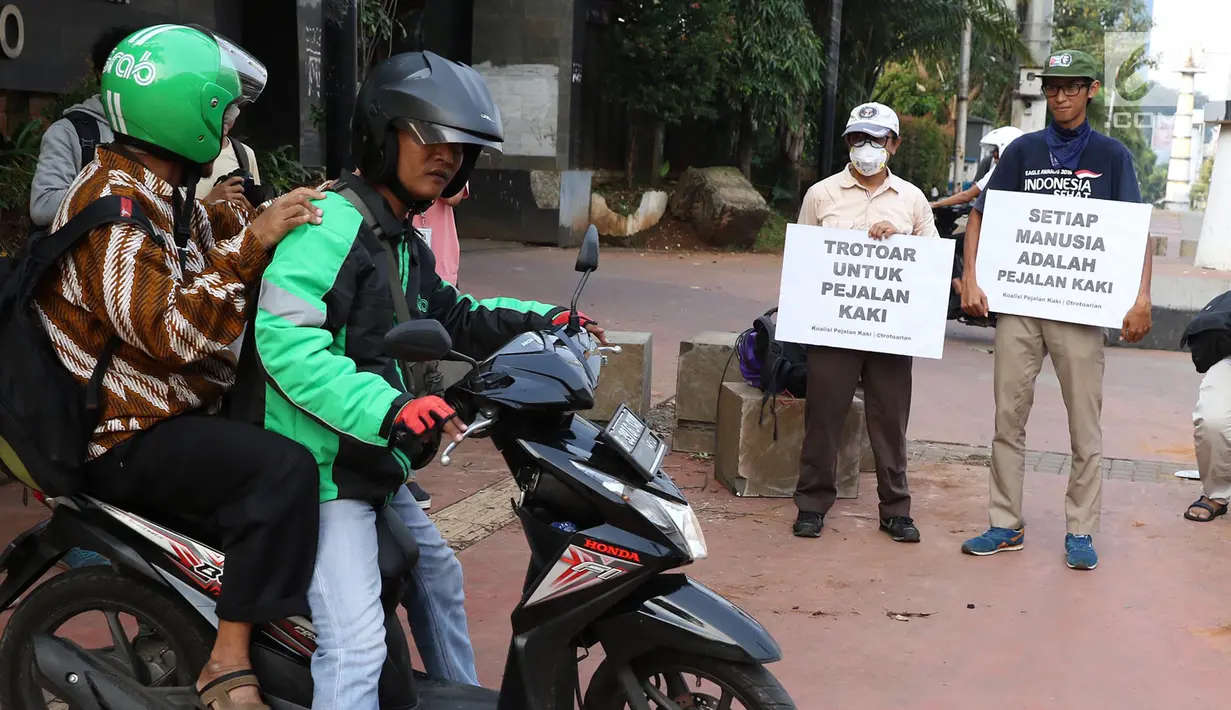 Aktivis Koalisi Pejalan Kaki (KPK) menghadang pengendara sepeda motor yang menerobos trotoar di depan Tempat Pemakaman Umum (TPU) Menteng Pulo, Jalan Casablanca, Jakarta Selatan, Jumat (21/7). (Liputan6.com/ Immanuel Antonius)