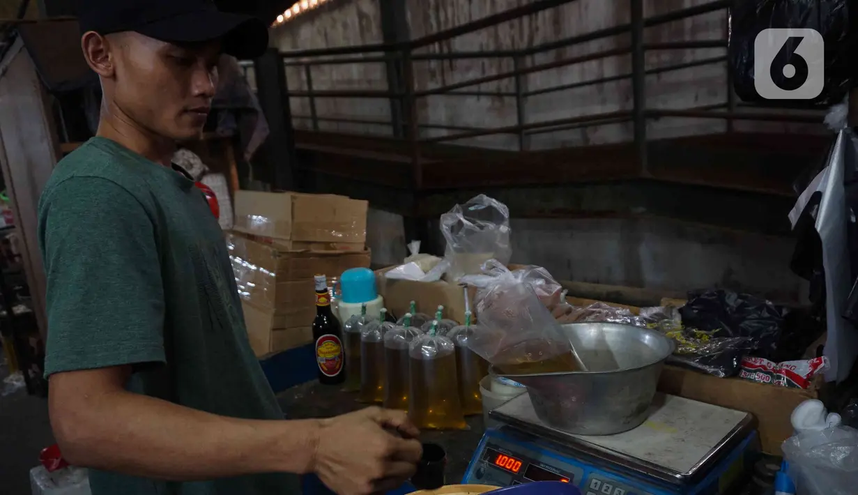 Pedagang menimbang minyak goreng curah di Pasar Senen, Jakarta, Selasa (31/5/2022). Pencabutan menyusul dikeluarkannya Permendag Nomor 30 Tahun 2022 yang mengatur ketentuan ekspor CPO dan turunan lainnya dan Permendag Nomor 33 Tahun 2022 tentang Tata Kelola Minyak Goreng Curah Sistem DMO-DPO. (Liputan6.com/Herman Zakharia)