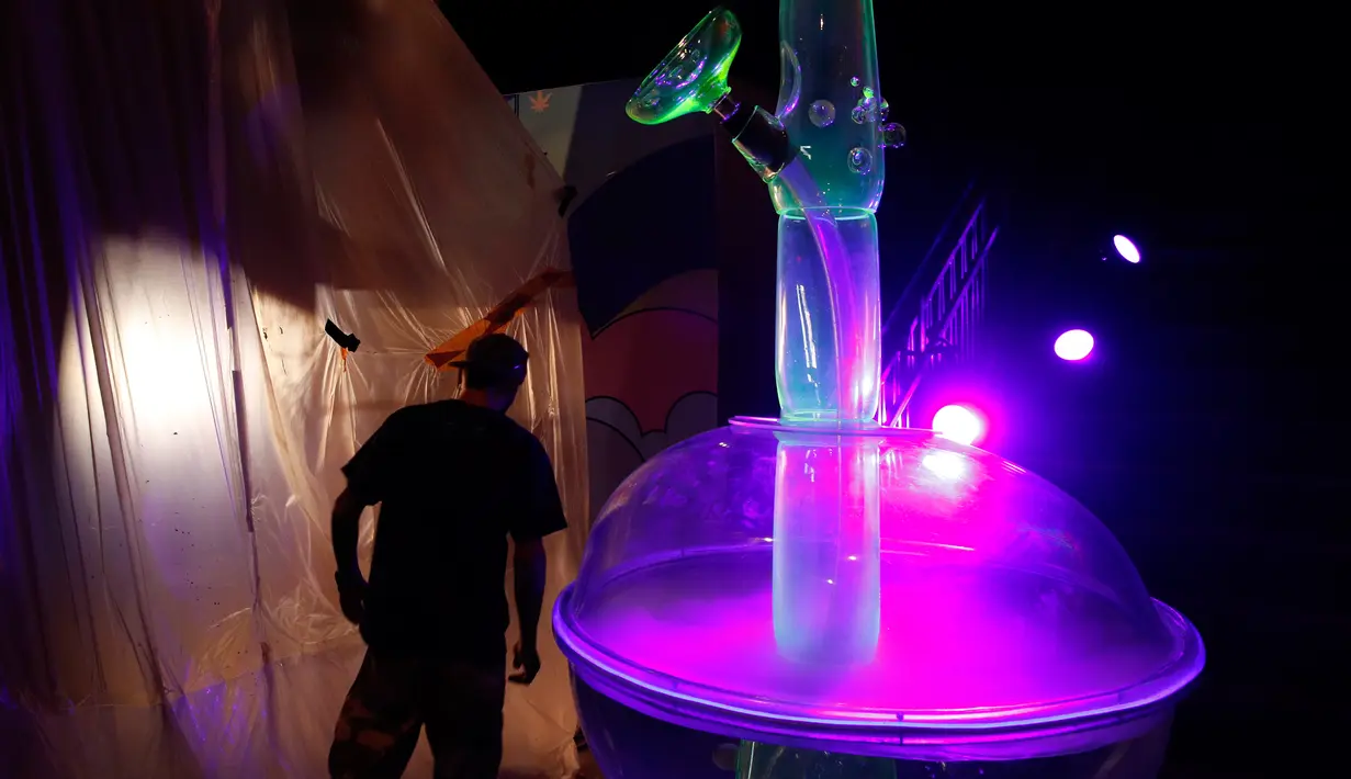 Seorang pria melihat gelas bong setinggi 24 kaki di Cannabition Cannabis Museum, Las Vegas, AS, Selasa (18/9). Museum ini menampilkan gelas bong yang lebih tinggi dari jerapah dan umbi ganja imitasi. (AP Photo/John Locher)