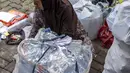 Seorang pegawai bank sampah menimbang sampah rumah tangga anorganik, berupa kardus dan botol plastik, Jakarta, Kamis 4 Juni 2026, sebagai bagian dari instruksi Pemprov DKI yang mewajibkan warga memilih dan memilah sampah untuk mengurangi beban sampah yang semakin menumpuk di ibu kota. (BAY ISMOYO/AFP)