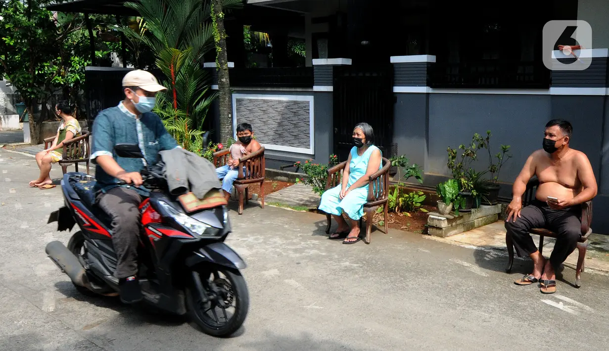 Pengendara melintasi warga yang sedang berjemur di pinggir jalan kompleks Perumahan Vila Cinere Mas, Depok, Kamis (8/7/2021). Saat ini lebih dari 50 warga Vila Cinere Mas terpapar Covid-19 dan menjalani isolasi mandiri di rumah masing-masing. (merdeka.com/Arie Basuki)