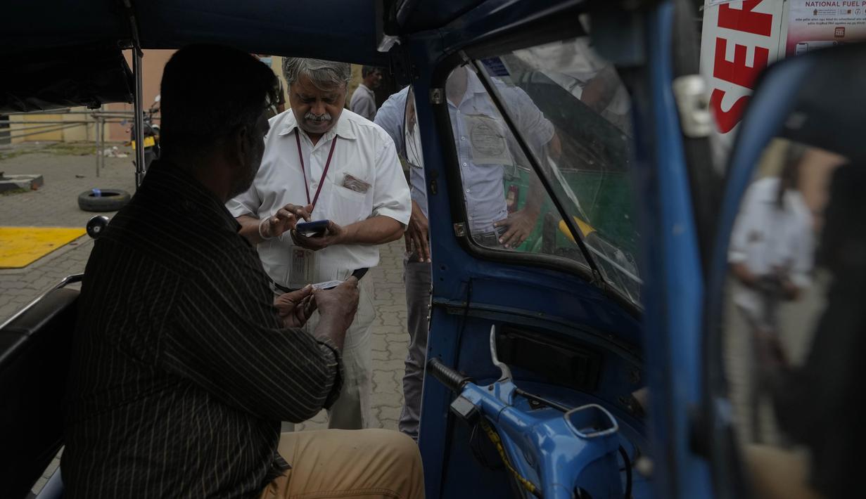 Seorang pekerja memindai kode QR sebelum mengisi bensin ke kendaraan di sebuah pompa bensin di Kolombo, Sri Lanka, Senin, 1 Agustus 2022. Sri Lanka memperkenalkan distribusi bahan bakar menggunakan kode QR pada hari Senin sebagai bagian dari penerapan kuota mingguan untuk pengendara. (AP Photo/Eranga Jayawardena)